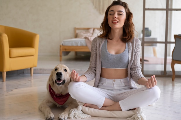 Mujer de tiro completo meditando con perro