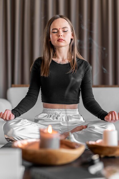 Mujer de tiro completo meditando en el sofá