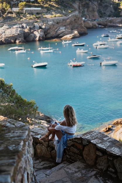 Mujer de tiro completo mirando barcos