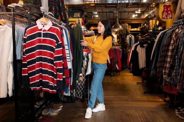 Mujer de tiro completo mirando ropa