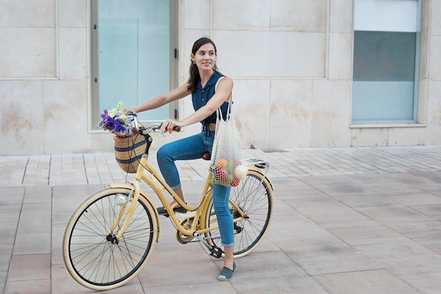 Mujer de tiro completo montando bicicleta