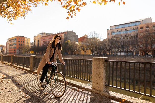 Mujer de tiro completo montando bicicleta