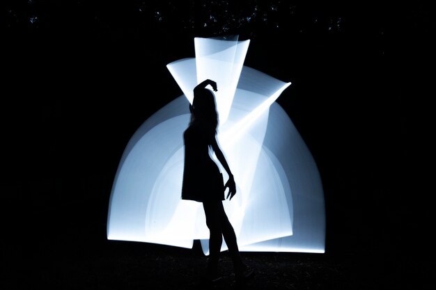 Mujer de tiro completo moviéndose con luz blanca.