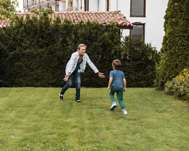 Mujer de tiro completo y niño corriendo