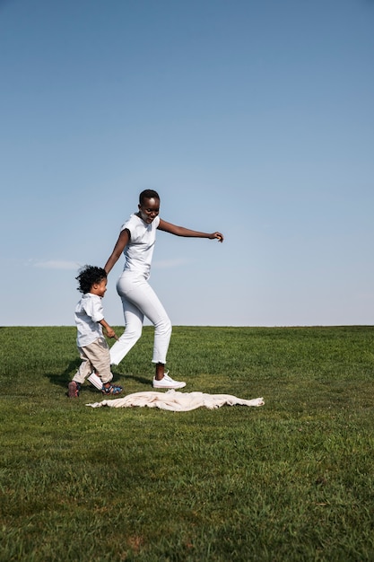 Foto gratuita mujer de tiro completo y niño corriendo