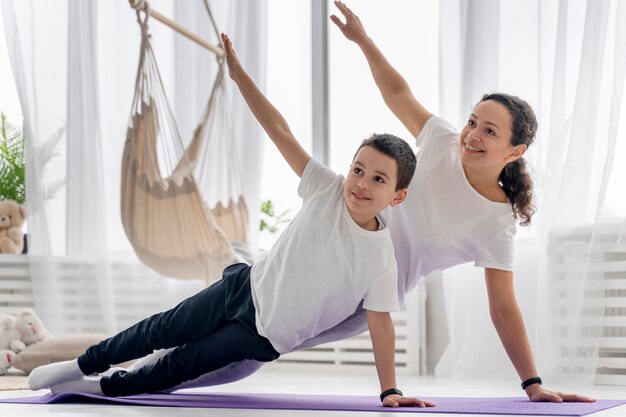 Mujer de tiro completo y niño haciendo deporte