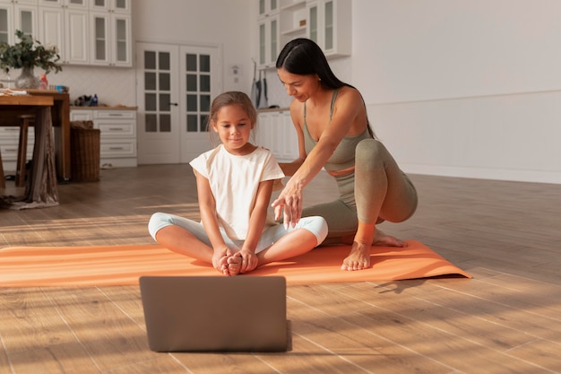 Foto gratuita mujer de tiro completo y niño con laptop