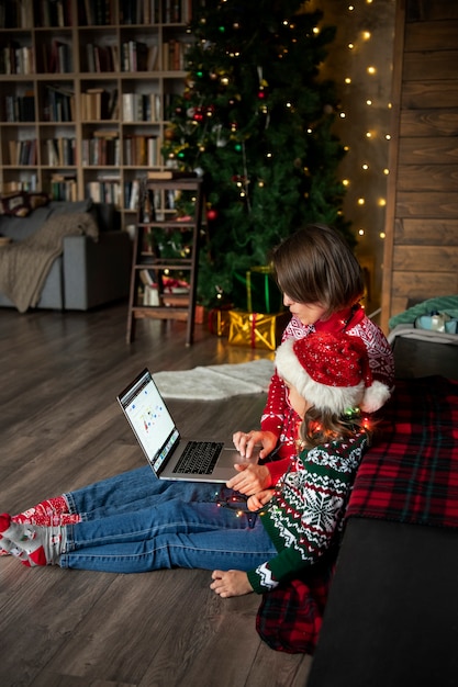 Mujer de tiro completo y niño con laptop