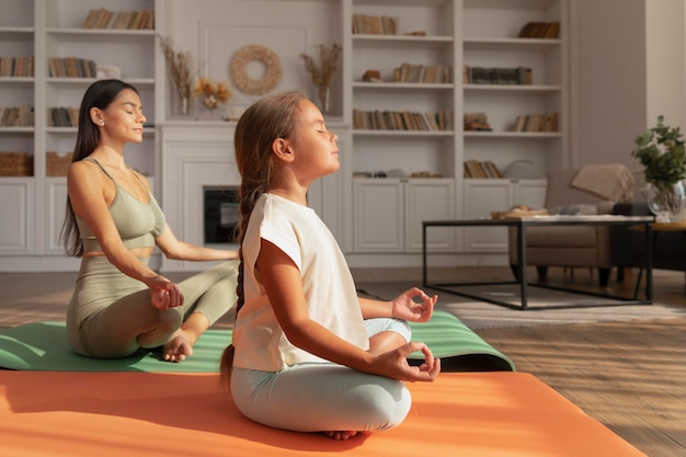 Foto gratuita mujer de tiro completo y niño meditando