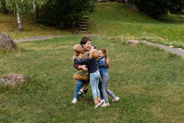 Mujer de tiro completo y niños abrazándose