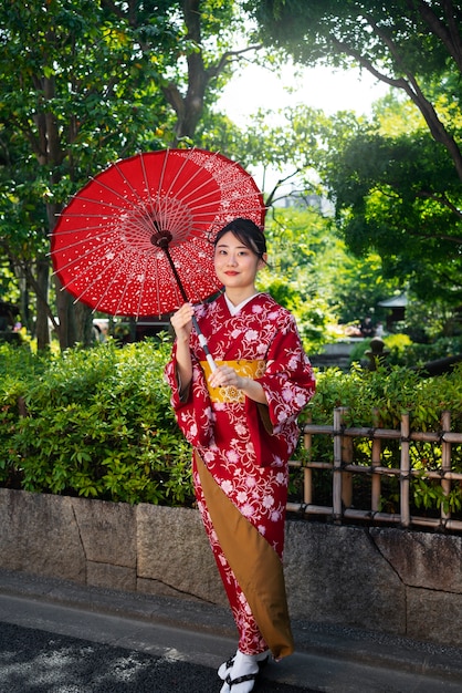 Mujer de tiro completo con paraguas wagasa