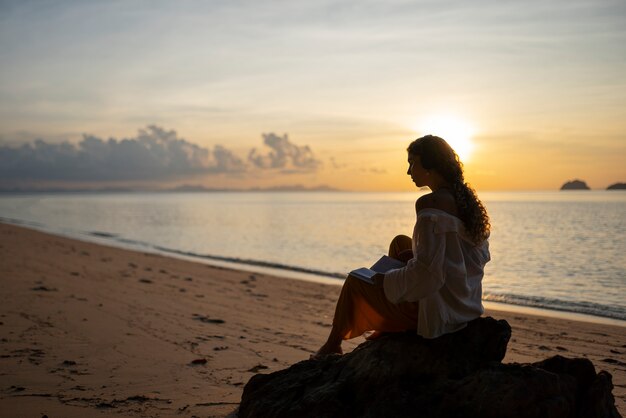 Mujer de tiro completo pasando un día sola en la playa.