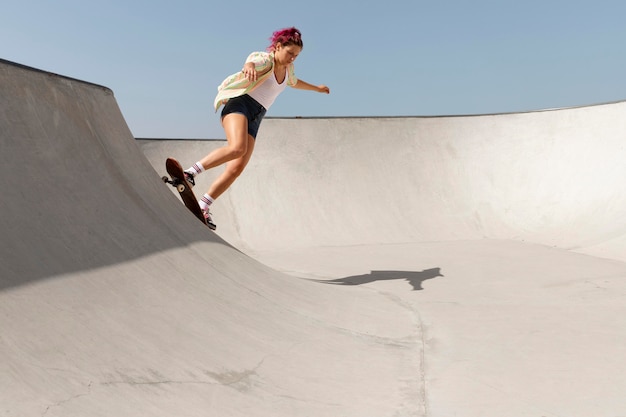 Foto gratuita mujer de tiro completo con patineta