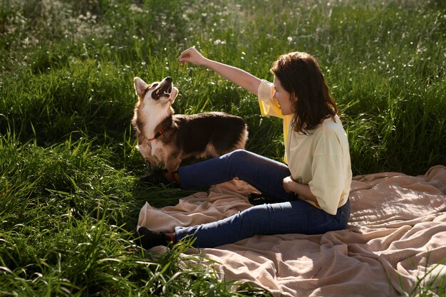 Mujer de tiro completo con perro al aire libre