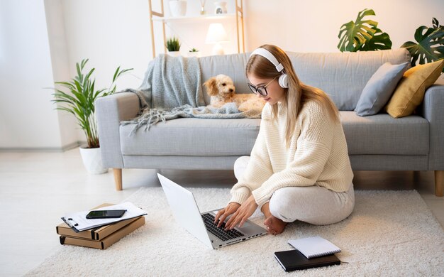 Mujer de tiro completo y perro en casa