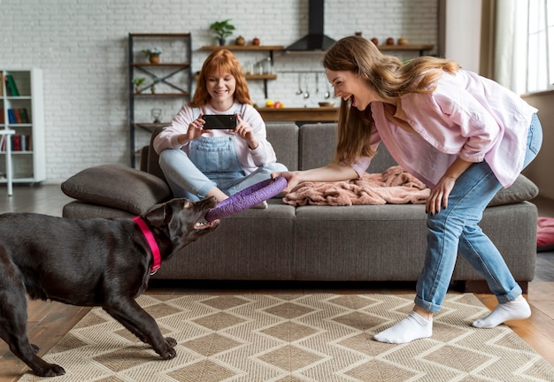 Foto gratuita mujer de tiro completo y perro divirtiéndose