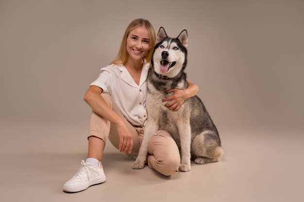 Mujer de tiro completo con perro en estudio