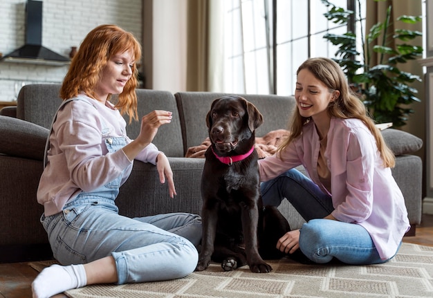 Mujer de tiro completo y perro con golosinas