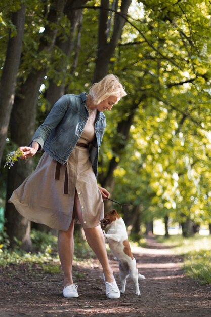 Mujer de tiro completo con perro en el parque