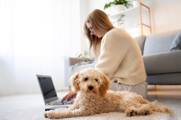 Mujer de tiro completo y perro en el piso