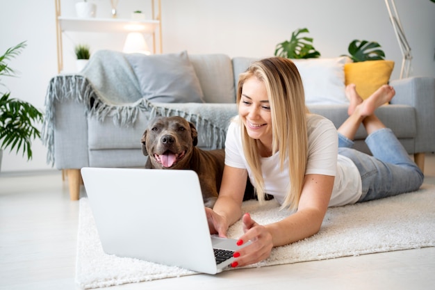 Mujer de tiro completo y perro en el piso