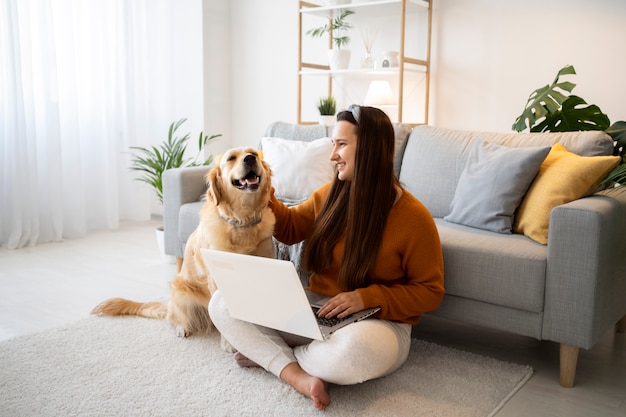 Foto gratuita mujer de tiro completo con perro y portátil