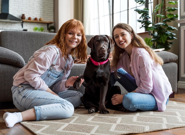 Foto gratuita mujer de tiro completo y perro posando en el piso