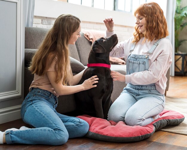 Mujer de tiro completo y perro en la sala de estar