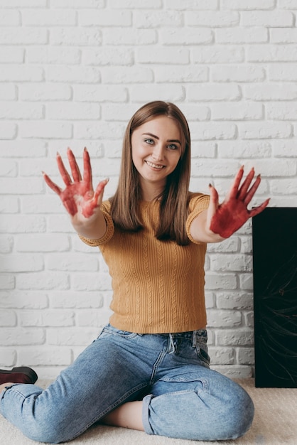 Mujer de tiro completo con pintura en las manos