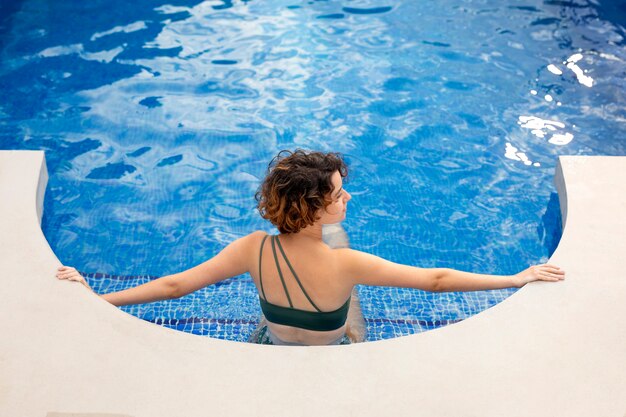 Mujer de tiro completo en la piscina