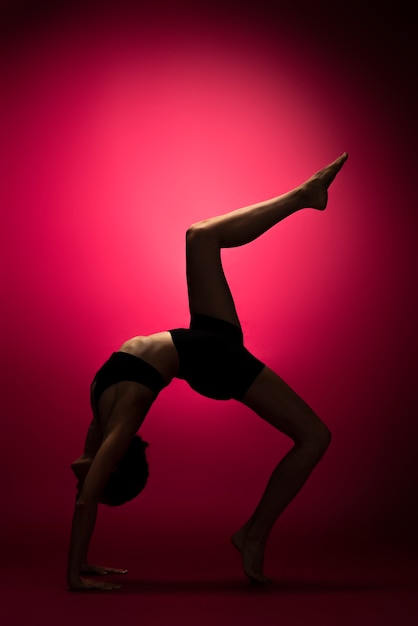 Mujer de tiro completo posando en estudio luz roja