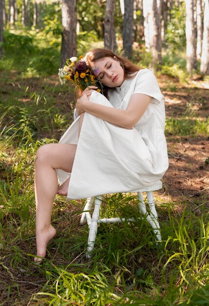 Mujer de tiro completo posando con flores