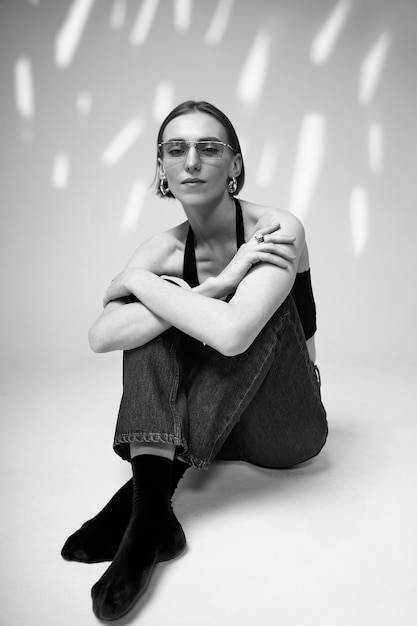 Foto gratuita mujer de tiro completo posando con gafas en blanco y negro