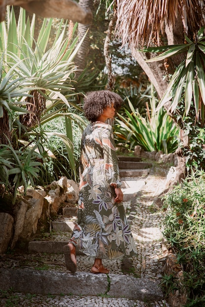 Mujer de tiro completo posando en un jardín romántico