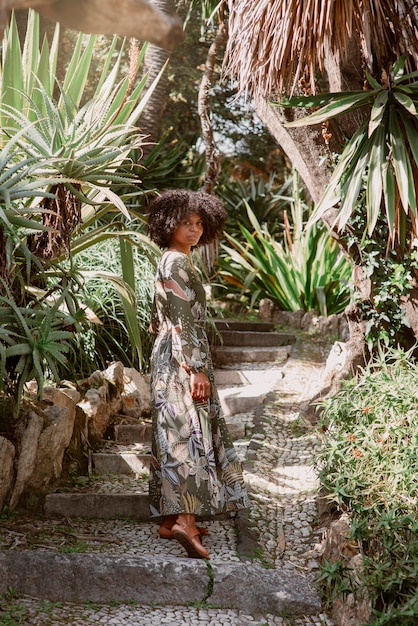 Mujer de tiro completo posando en un jardín romántico