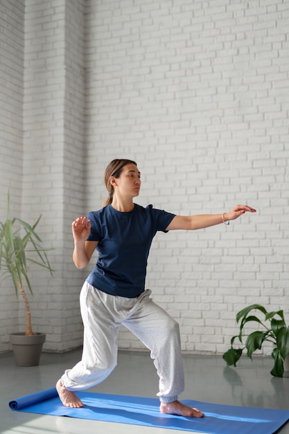 Foto gratuita mujer de tiro completo practicando tai chi en interiores