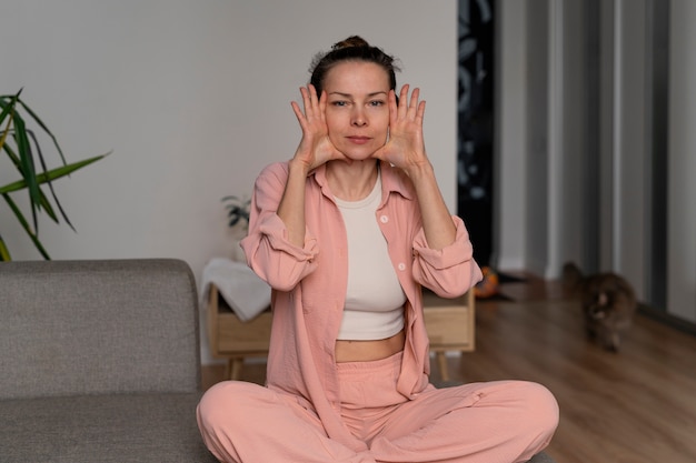 Mujer de tiro completo practicando yoga facial