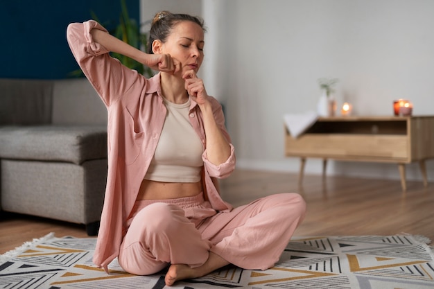 Mujer de tiro completo practicando yoga facial