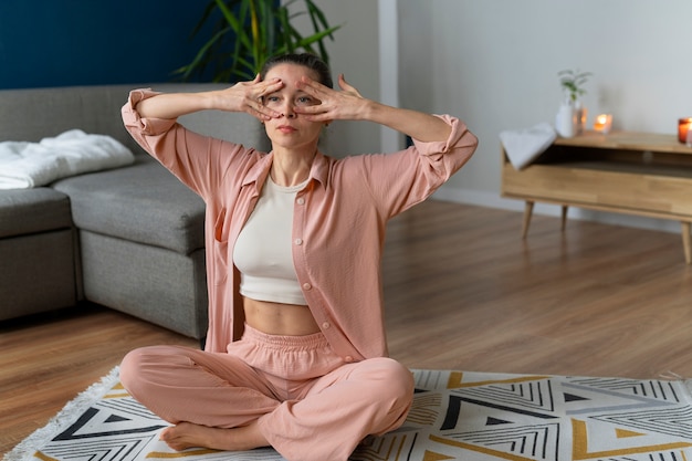 Mujer de tiro completo practicando yoga facial