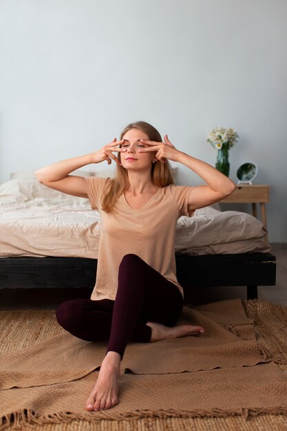 Mujer de tiro completo practicando yoga facial