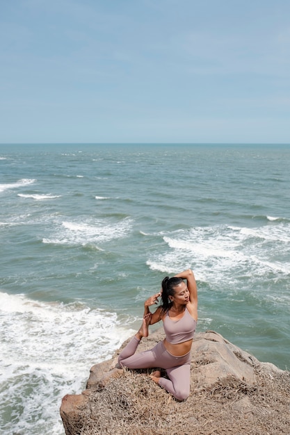 Mujer de tiro completo que se extiende en la naturaleza