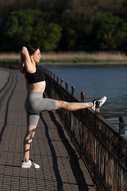 Mujer de tiro completo que se extiende en la naturaleza