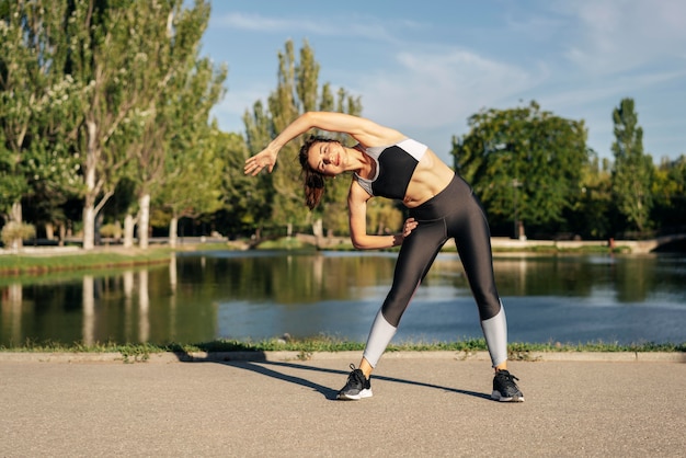 Mujer de tiro completo que se extiende en el parque