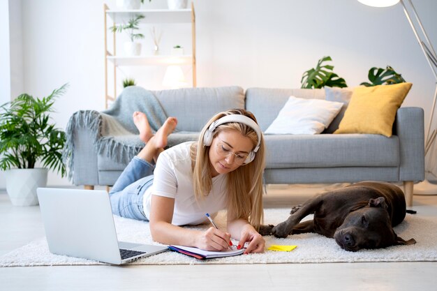 Mujer de tiro completo que trabaja con auriculares