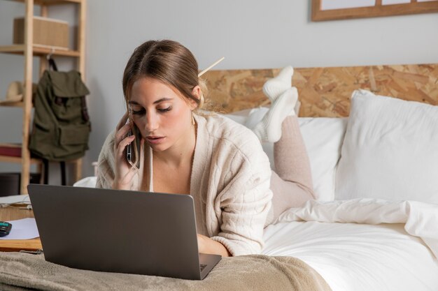 Mujer de tiro completo que trabaja en la cama