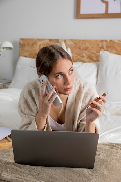 Mujer de tiro completo que trabaja en la cama