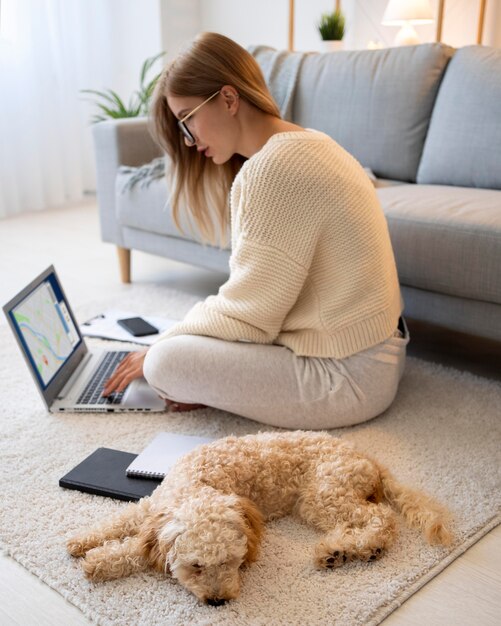 Mujer de tiro completo que trabaja en la computadora portátil