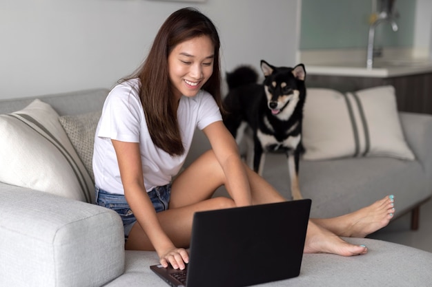 Mujer de tiro completo que trabaja en la computadora portátil