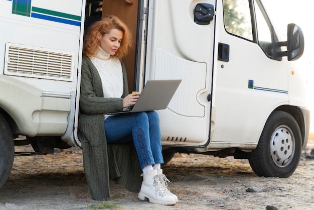 Mujer de tiro completo que trabaja en la computadora portátil