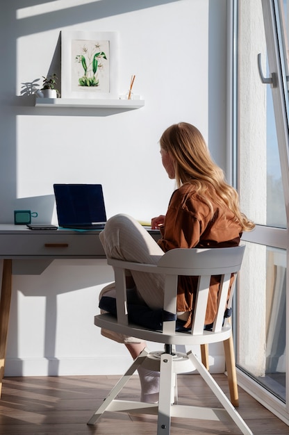 Mujer de tiro completo que trabaja en el escritorio